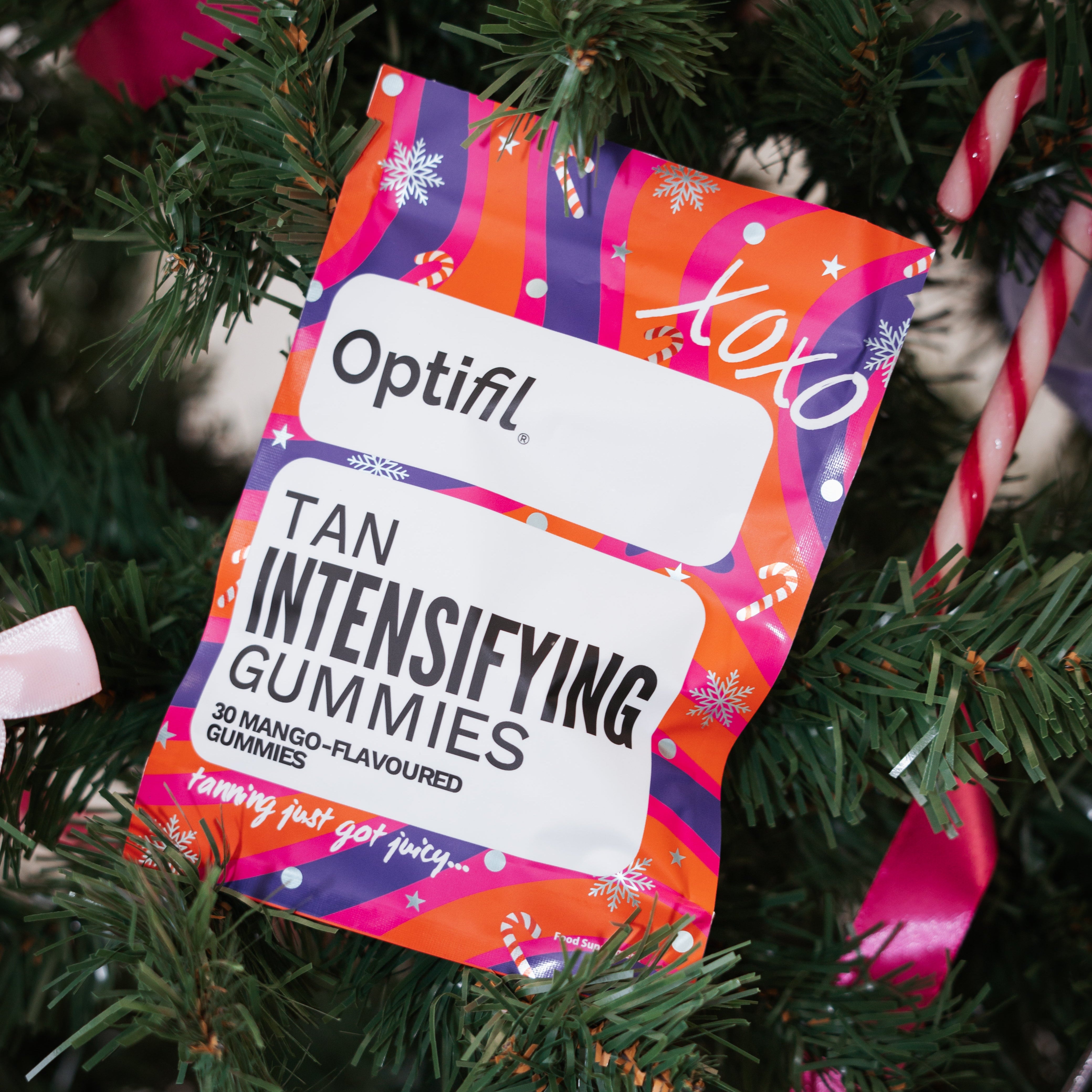 Optifil tan intensifying gummies packaging on a Christmas tree