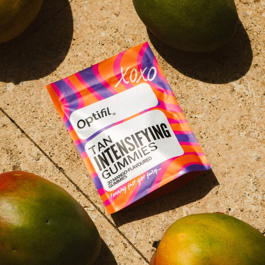 Optifil Tan Intensifying Mango Gummies on a sunlit surface with fresh mangoes - Viral Tan Gummies for skincare and beauty loves in the UK